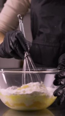 Pasta şefi muhallebi hazırlıyor un ve yumurtayı bir kasede karıştırıyor. Adım adım eklerlerin tarifi. Dikey video