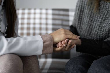 Doktor umut veriyor. Yakın plan bir doktor yaşlı bir hastayla konuşuyor elini tutuyor, yaşlı bir insanı destekliyor. Boşluğu kopyala