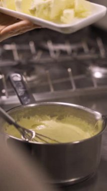 Kekler için krema pişirme sürecinde profiterol yapımında aşama aşama puding karıştırmak. Dikey video