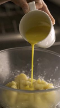 Ekler için muhallebi hamuru yapma süreci, yumurta hamur ile birlikte cam kaseye ekleniyor. Dikey video