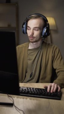 Kafkasyalı genç siber sporcu oyuncular evdeki bilgisayarda gece bilgisayar oyunu oynuyorlar. Erkek oyuncu oynarken şok edici bir şaşkınlık yaşıyor.,