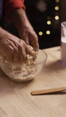 Zencefilli çörek pişirme, Noel arifesinde çörek pişirme. Erkek fırıncı kasede hamur yoğuruyor. Yakın çekim, dikey video