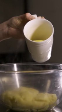 Ekler için muhallebi hamuru yapma süreci, yumurta hamur ile birlikte cam kaseye ekleniyor. Dikey video