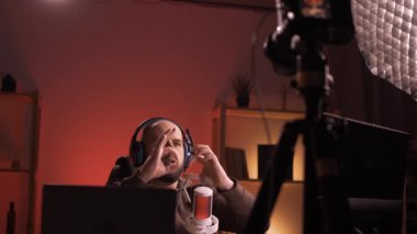 Profesyonel blogger streamer etkileyicisi abonelerle sohbet ediyor canlı yayın yapıyor ve geceleri odada oturarak online yayın sunuyor. Boşluğu kopyala
