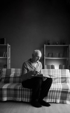 Yalnız bir dul adam eski fotoğraflara bakıyor. Albümdeki koltukta oturuyor. Oturma odasında, siyah beyaz bir fotoğraf. Emeklilik ve yalnızlık kavramı