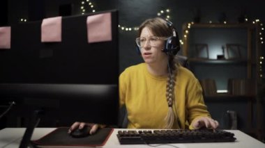 Gözlüklü yetişkin kadın oyuncu kişisel bilgisayarında online video oyununda bir tur oynuyor. Profesyonel oyuncu çoklu oyunculu online şampiyonluğu seviyor..