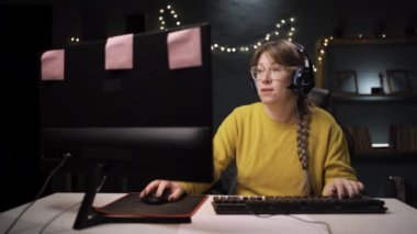 Gözlüklü bayan oyuncu kişisel bilgisayarında online video oyunu oynuyor. Silahları açan jest, pişmanlık, özür, durumun tanınması ve uzlaşmaya hazırlık anlamına geliyor..