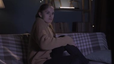 Geceleri evde yalnız beyaz bir kadın televizyon seyrediyor, korku duyguları yaşıyor, korku filmleri izliyor..