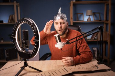 Komplo teorisyeni-blog yazarı akıllı telefon kullanarak çevrimiçi vlog için video çekiyor. Sosyal medyada podcast kanalı için sakallı şizofrenik içerik oluşturucu kaydı..