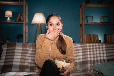 Gecenin geç saatlerinde şok olmuş ve korkmuş bir kadın patlamış mısır yiyor ve TV 'de korku filmi seyrediyor oturma odasında dinleniyor. Boşluğu kopyala