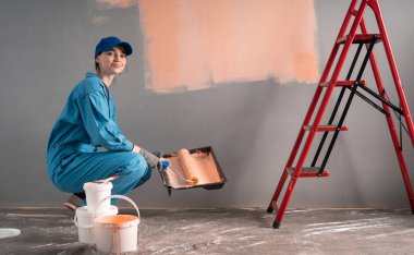 Ressam silindiri boyayla doldurur. Evlerin ve dairelerin onarımı