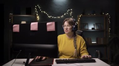 Oyuncu, mikrofonda takımla konuşuyor. Online video oyununda kazananı kutluyorlar. Kulaklıklı kadın diğer oyuncularla oynuyor. Boşluğu kopyala