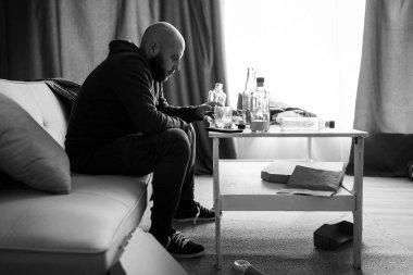 Genç üzgün sarhoş adam alkol içiyor, kendini yalnız hissediyor ve acı ve duygusal stresten umudunu kesiyor. İnsanlar ve alkol bağımlılığı, bağımlılık ve erkek depresyonu kavramı. Boşluğu kopyala