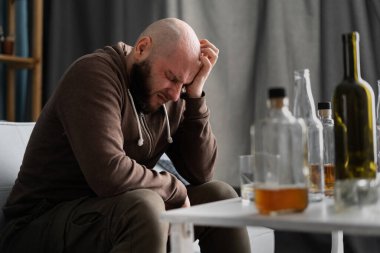 Bir şişe viskiden depresyona giren erkek içici. İçki mahmurluğu. Boşluğu kopyala