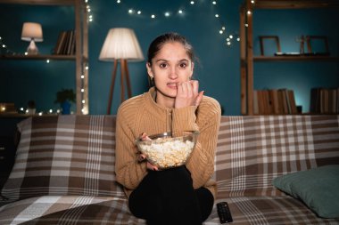 Gergin kadın izleyiciler gece televizyon seyredip evde patlamış mısır yiyerek tırnak yiyorlar. Boşluğu kopyala