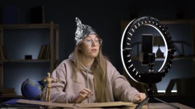Yüzük ışığı ve akıllı telefonu olan garip çılgın blogcu, video blogunda yayınlanan komplo teorisi yayınlayan paranoyak kadın. blog yazma, teknoloji ve komplo teorisi kavramı.