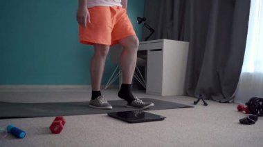 Fitness, kilo verme konsepti. Aktif spor çalışmalarının sonucu olarak insan terazinin üzerinde duruyor. Boşluğu kopyala
