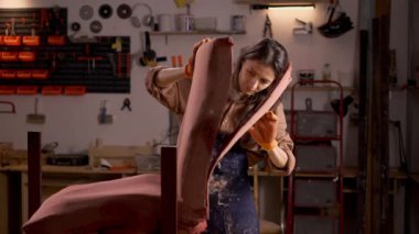 Eski koltuğun döşemesini değiştirin, genç bayan restoratör antika ahşap koltuktan eski bir bez kaplamayla çalışıyor. Boşluğu kopyala