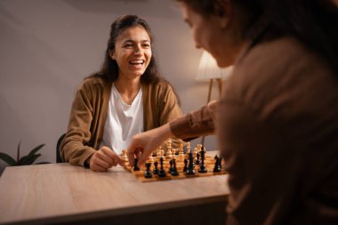 eğlence, strateji ve bağlanma konsepti - evde satranç oynayan iki kadın, düşünceli oyundan zevk alıyor, kopyalama alanı