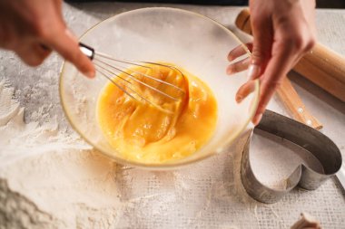 Cam bir kasede pürüzsüz yumurta çırpmak, hamur pişirmek. Sahne, dokusunu ve hareketini rahat bir mutfak ortamında yakalıyor. Boşluğu kopyala