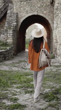 Sırt çantalı gezgin antik taş kemer yolunda yürüyor, tarihi yerleri keşfediyor, şapkalı sıradan kıyafetler giyiyor, eski mimariyi keşfediyor, ortaçağ kalesinde maceranın tadını çıkarıyor. Boşluğu kopyala