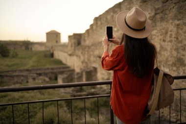 Sırt çantalı genç bir turist Ukrayna 'daki güzel antik kale duvarlarının fotoğraflarını çekiyor. Boşluğu kopyala