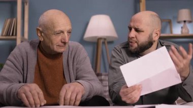 Emeklilik, mali ve vergi konsepti. Faturaları hesaplayan oğlu olan kıdemli bir baba. İnsanlar, bütçe ve evde tasarruf. Boşluğu kopyala