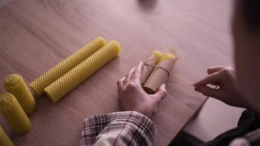 Çevrimiçi işletme sahibi atölyesinde sevkiyat için balmumu mumları paketliyor. Diy konsepti. Üst görünüm