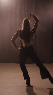 Genç striptizci, yüksek topuklularla kulüpte dans ediyor. Boşluğu kopyala