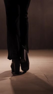 Arka planda tanınmayan ayaklı, tanınmayan bir dansçı var. Striptizci