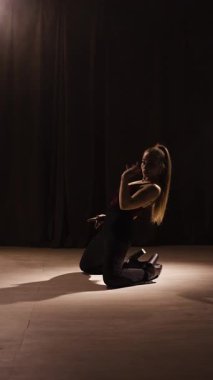 Yüksek tepelerde striptiz yapan uzun saçlı güzel bir kadın. Dikey video