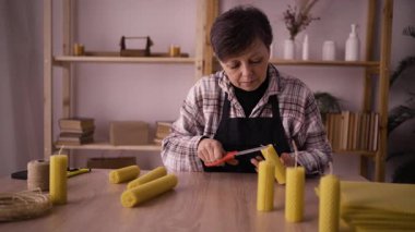 Önlüklü orta yaşlı bir kadın atölyede el yapımı dekorasyon yapıyor. Hobiler ve DIY konsepti
