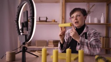Kadın zanaatkar video yayını yapıyor ya da akıllı telefondan el yapımı mum yapmayı öğreniyor. Kadın cep telefonuyla video bloğu çekiyor, mum yapıyor. Başlangıç, sme ve günlük tutma kavramı