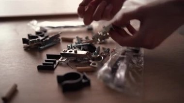 Ahşap mobilyaları monte etmeye hazırlanan adam atölyede mobilya yerleştirme seti açıyor, yakın plan.