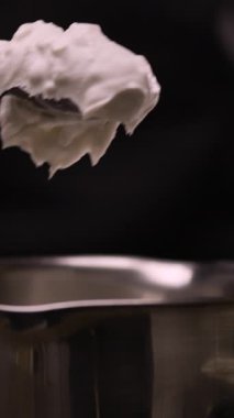 Erime, vejetaryenlik ve keto diyeti konsepti için tencereye katı hindistan cevizi yağı katılmış kaşığı kapat. Dikey video