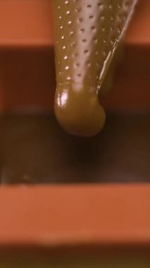 Çikolata kokulu karamel ya da erimiş sütlü çikolatayı pasta poşetindeki silikon kalıplara yakın çekim. Makro manzara. Dikey video