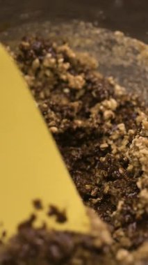 Bir kasede erimiş çikolatayla karıştırılan fındık kırıntılarını adım adım, el yapımı şekerler yapmak için. Dikey video