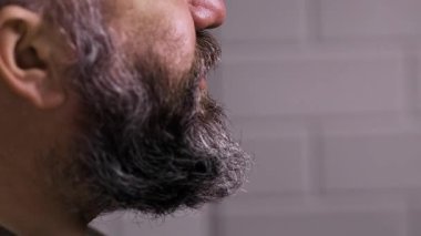 Sakallı adam lezzetli çerez patlamış mısır çiğniyor. Yakın plan. Yavaş çekim