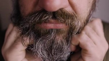 Rahatsız edici kaşıntı konsepti. Sakalını kaşıyan yetişkin bir adam deri iltihabı ve alerji geçiriyor. Yakın plan.