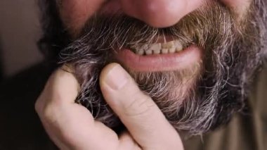 Rahatsız edici kaşıntı konsepti. Sakalını kaşıyan yetişkin bir adam deri iltihabı ve alerji geçiriyor. Yakın plan.