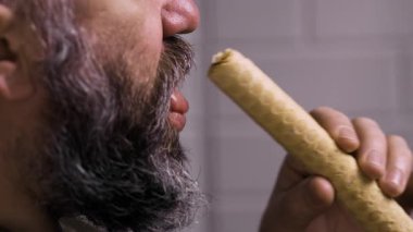 Tatlı konsepti ye. Sakallı bir adam krep yiyor ve yoğun süt dolguluyor. Yakın plan.