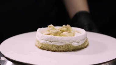 Adım adım muz dolgulu benta keki yapmak. Pasta şefi ilk kattaki pastayı dikkatlice muz dolgusu ile doldurur. Yedinci adım.