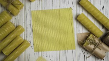 El yapımı üretim sürecini, hobiyi ve küçük işletme kavramını gösteren balmumu çarşaflarından mum yapan eller.