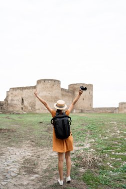 Sırt çantalı kadın turist Akkerman 'daki kaleye gelişini kutluyor. Arka görünüm
