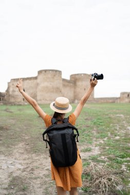Sırt çantası ve kamerasıyla Avrupa 'daki tarihi UNESCO kalesini gezen gezgin, Ukrayna' daki yaz turu ve kültür mirasının keyfini çıkarıyor. Sırt çantalı arka plan