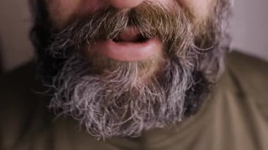 Adam sistematik hareket eder çene kemirir ağzındaki bir şeyi çiğner diliyle dişler alır. Yakın plan.