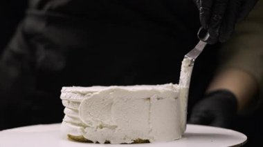 Adım adım muz dolgulu benta keki yapmak. Bir hamur işi şefinin yakın planında özel bir spatulayla yanında krem peyniri düzleştirirken dikkatli ol. 15. adım.