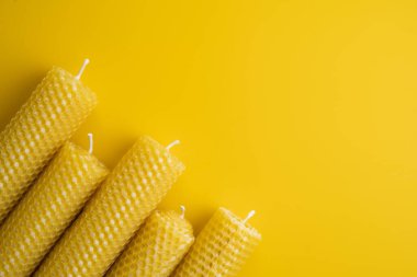 Sarı arka plana yerleştirilmiş balmumu mumları. Düz Yat. Boşluğu kopyala