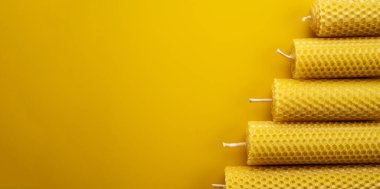 Sarı yüzeyde balmumundan el yapımı mumlar. Düz Yat. Pankart. Boşluğu kopyala