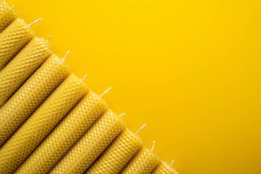 Canlı sarı yüzeyde el yapımı balmumu mumlar. Düz Yat. Boşluğu kopyala